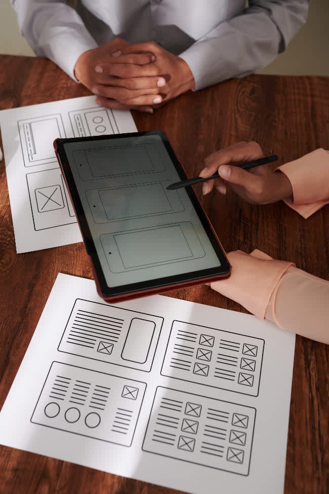 UI Designer Explaining Ideas to Client Image of Instructional Design professionals discussing Slide Design strategies inspired by Presentation Zen.